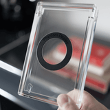 Hand holding Phantom Display Magneto case showing branded magnetic ring mount on clear acrylic back