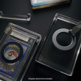 Phantom Display Magneto on ribbed stand with PSA Japanese Pokemon card on glass table in modern living room