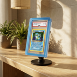 Phantom Display Magneto Color case in blue with Prism faceted edges, holding PSA GEM MT 10 1st Edition Blastoise, on Magneto Desk Stand with plants #color_blue